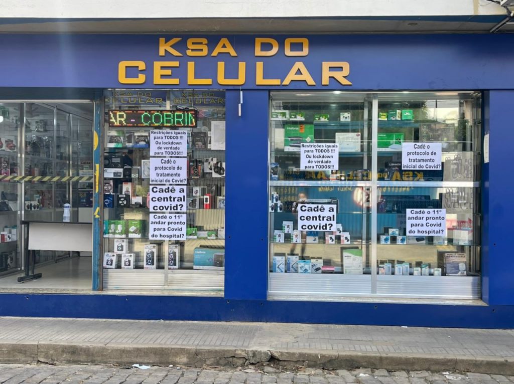 Comerciantes fazem protesto com cartazes nas vitrines de suas lojas