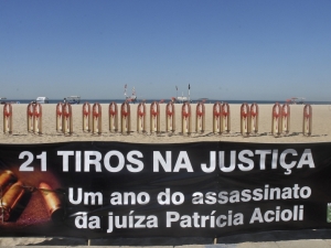 Uma faixa trazia a frase: “21 tiros na Justiça: um