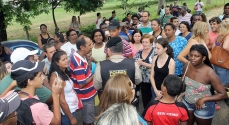 População fazendo manifestação em frente à feira.