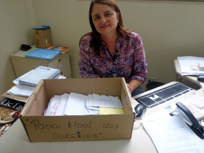 A gerente da ag&ecirc;ncia, Adriana  Alves dos Santos e as cartas das crian&ccedil;as para Papai Noel.