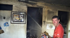 Funcionário da Defesa Civil faz o trabalho de resfriamento do quarto depois de apagadas as chamas