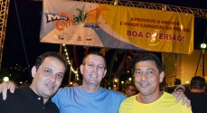 À frente da faixa que anuncia o carnaval em Miraí, o prefeito José Ronaldo com Fausto e Sebastião