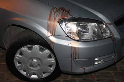 Marcas de sangue na lataria do carro que estava estacionado perto do sem&aacute;foro