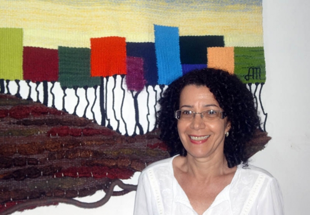 A artista e tecelã Alcione Martins á frente de um de seus tapetes
