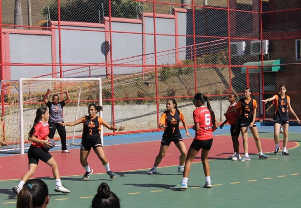 A equipe de handebol feminino do Sesi Cataguases joga de camisa vermelha