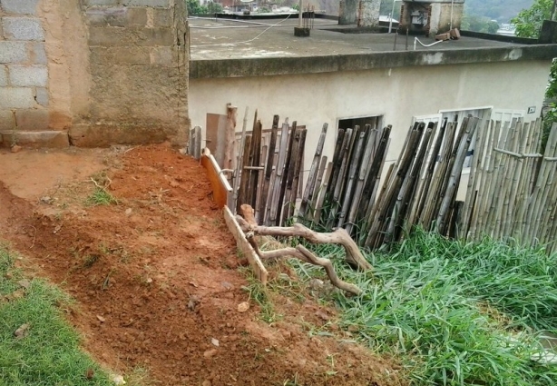 A enxurrada descia pela rua e caía na residência com cerca de bambu à frente