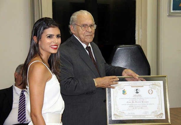 Gabriela, nora do homenageado, entrega a Comenda a Tarcísio Henriques