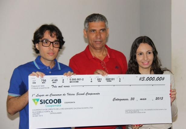 Os vencedores Gabriel e Priscila recebem o cheque das mãos de César Mattos