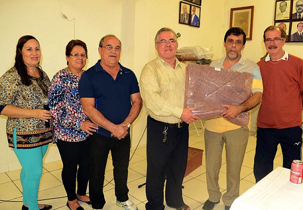 Sebastião Tatá recebe um dos cobertores das mãos do presidente do Lions Clube, Geraldo Luchini