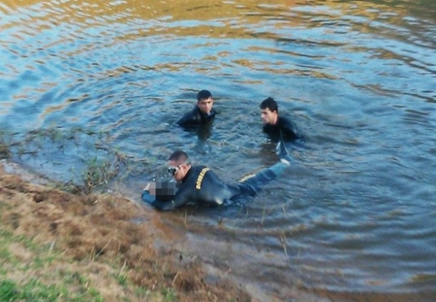 Equipe do Corpo de Bombeiros de Muriaé retiram o corpo do garoto do rio