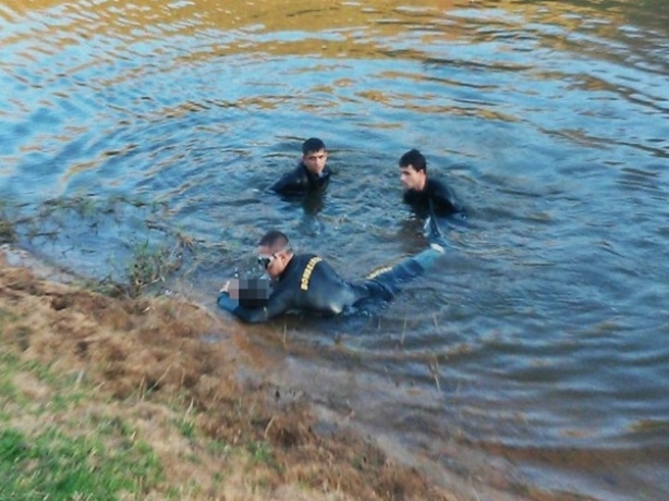 Equipe do Corpo de Bombeiros de Muria&eacute; retiram o corpo do garoto do rio