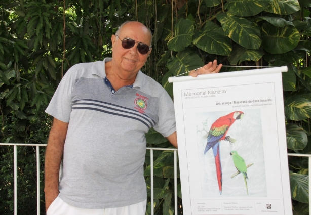 Cairu Teles exibe um dos banners de sua exposição "Passarada" que pretende montar na Praça Santa Rita