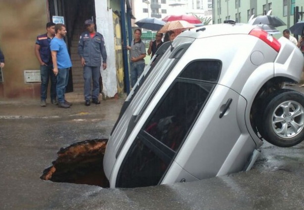 Metade do carro foi "engolido" pelo buraco no meio da rua (Foto: Kátia Fraga/Arquivo Pessoal)