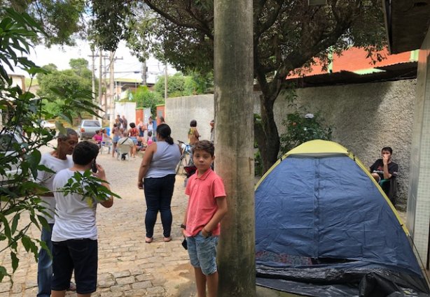 Uma barraca de camping está montada ao lado da escola abrigando um dos interessados em matricular um parente 