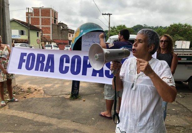 Rose Amaral, ao megafone, explica os problemas que a população enfrenta com o serviço de tratamento de esgoto feito pela Copasa